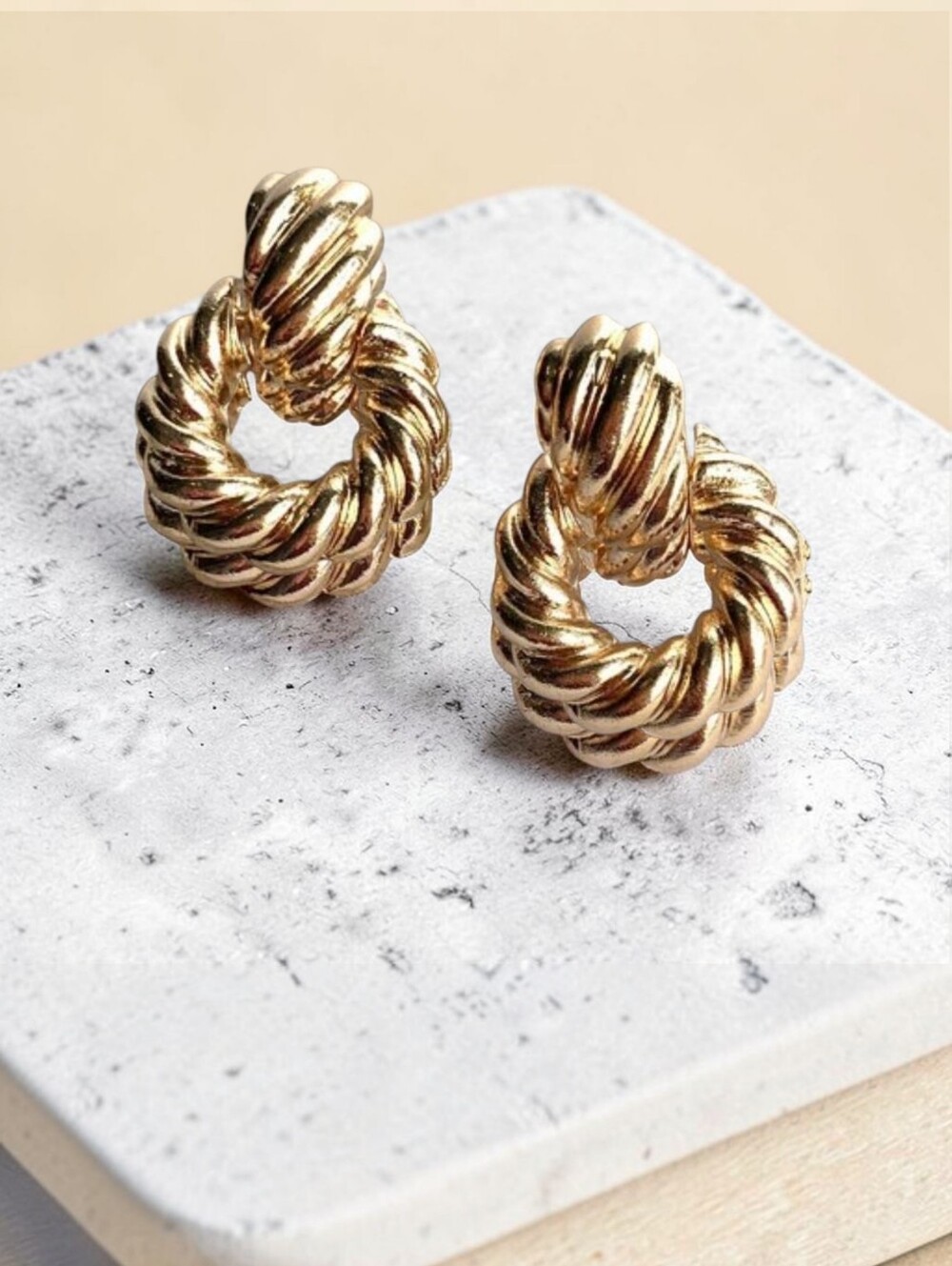 Gold dangle doorknocker earrings; one sided
